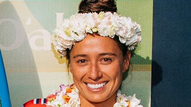 Malia Manuel poses in a Lei and a flower crown and smiles for the camera.